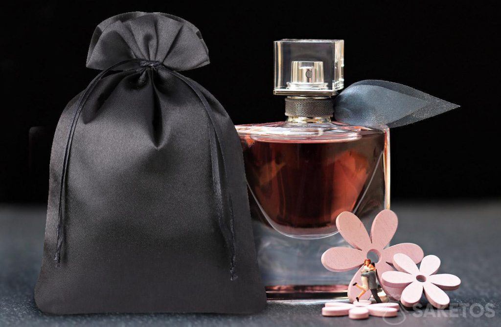 Perfumy zapakowane w satynowy woreczek prezentują się luksusowo.