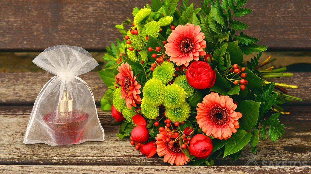 Woreczek z organzy z flakonem perfum i bukiet kwiatów