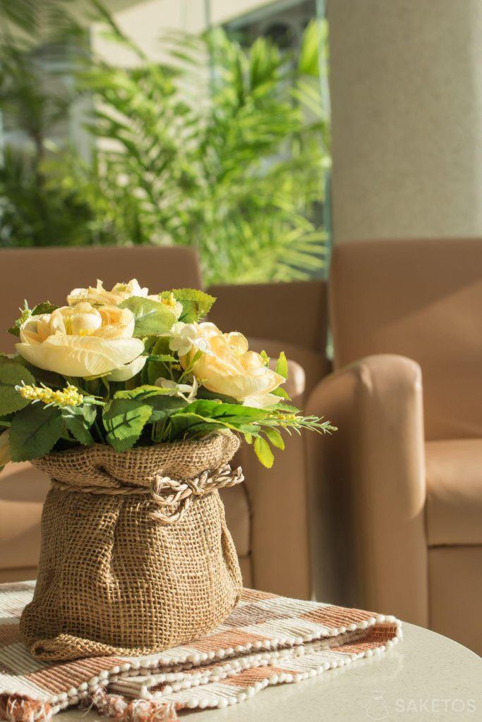 Kwiaty w osłonce z woreczka jutowego - urocza dekoracja stołu