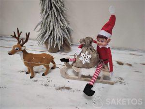 Naughty elf wiozący na saniach worek prezentów