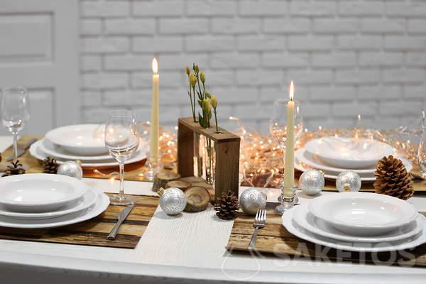 Świąteczny stół z białym obrusem - biały obrus i drewniane dodatki